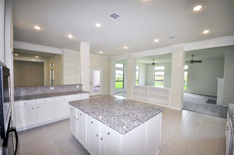 Tru White cabinets are topped with Bianco Primate Granite.