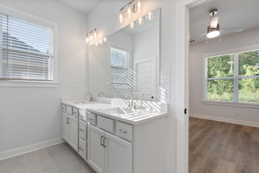 Dual vanity with white cabinetry, integrated sinks, and brushed nickel faucets