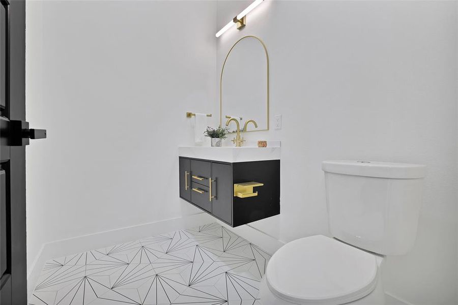 Bathroom with vanity, toilet, baseboards, and tile patterned flooring