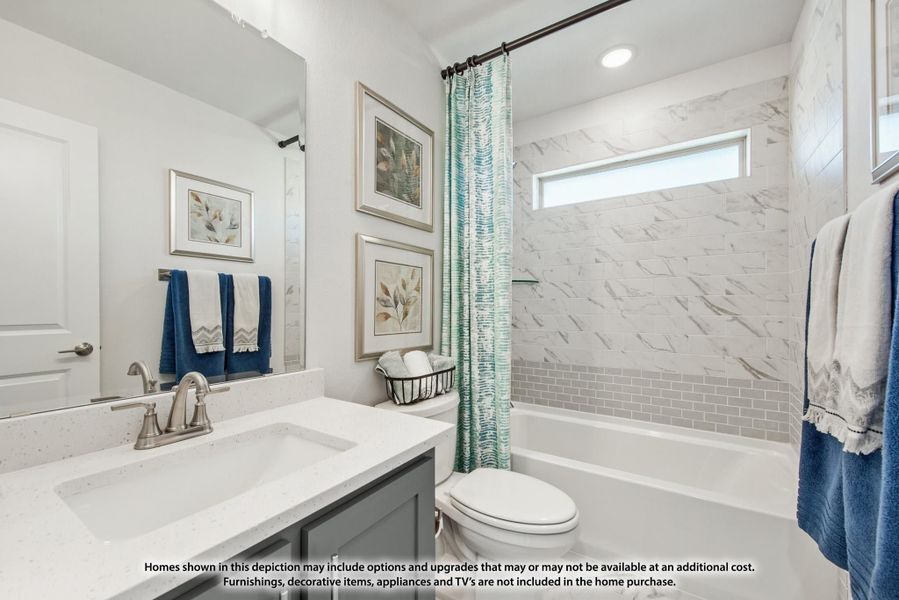 Bathroom with white quartz vanity, gray cabinets, and tiled shower-tub combo with curtain Bathroom with white quartz vanity, gray cabinets, and tiled shower-tub combo with curtain