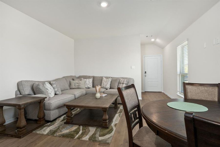 Living area with wood finished floors, recessed lighting, and vaulted ceiling Living area with wood finished floors, recessed lighting, and vaulted ceiling