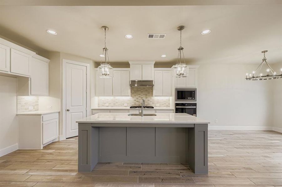 Kitchen featuring light wood-style flooring, pendant lighting, recessed lighting, and decorative backsplash