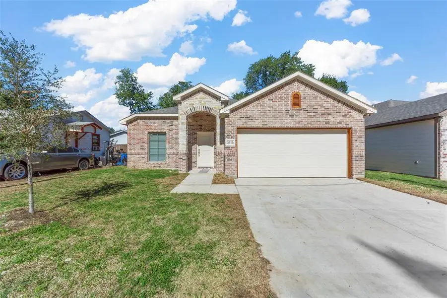 View of front of property featuring a garage and a front yard