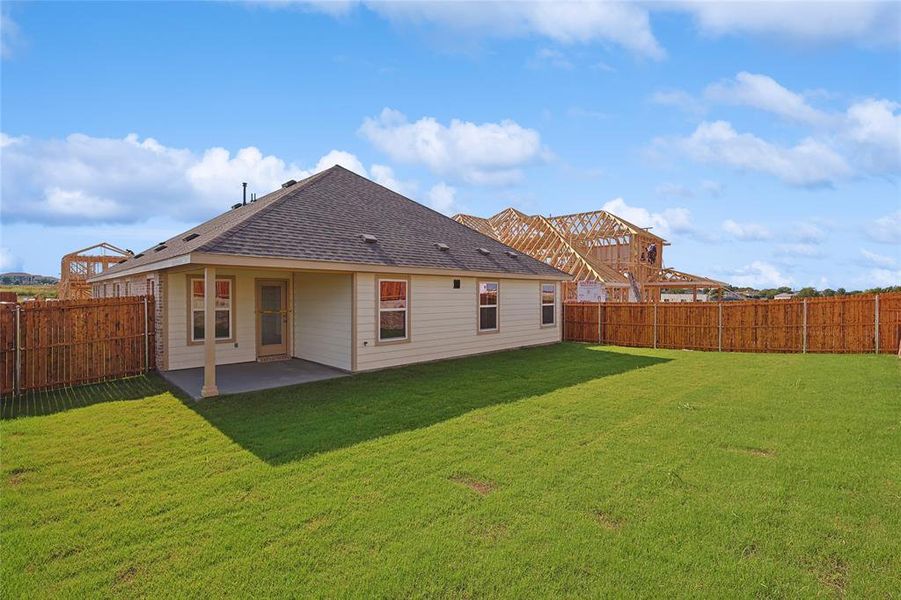 Back of property with a patio area and a lawn