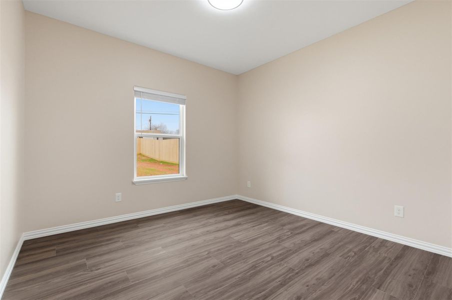 Unfurnished room featuring wood finished floors and baseboards
