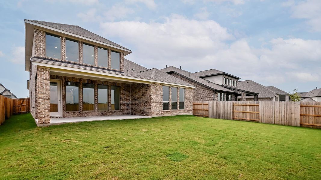 Back of house with brick siding, a patio, and a shingled roof