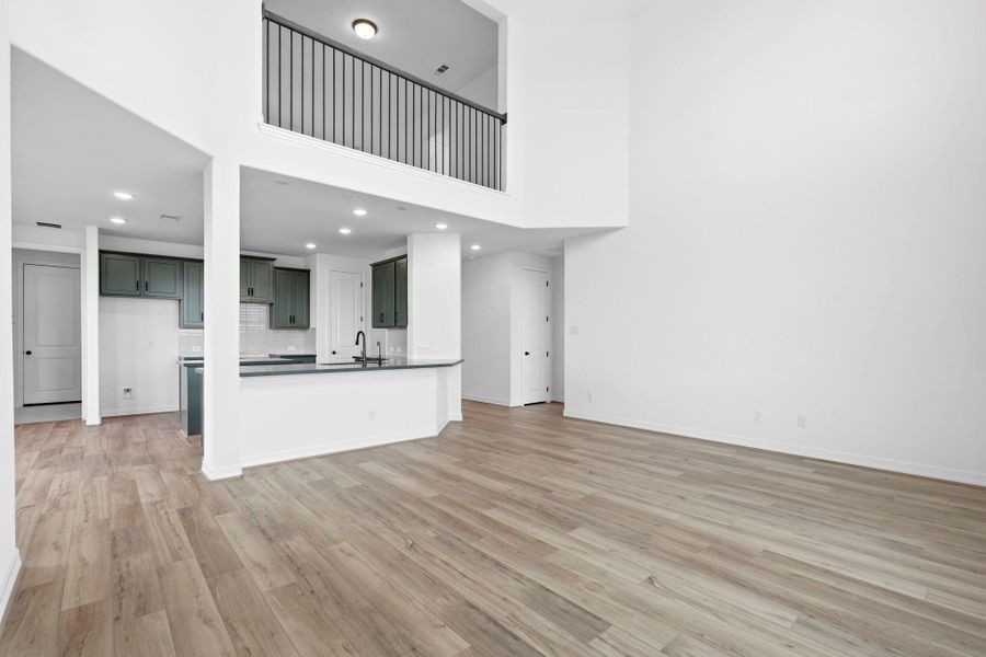 Spacious two-story family room with open flow to the kitchen, perfect for family gatherings and lifestyle living.