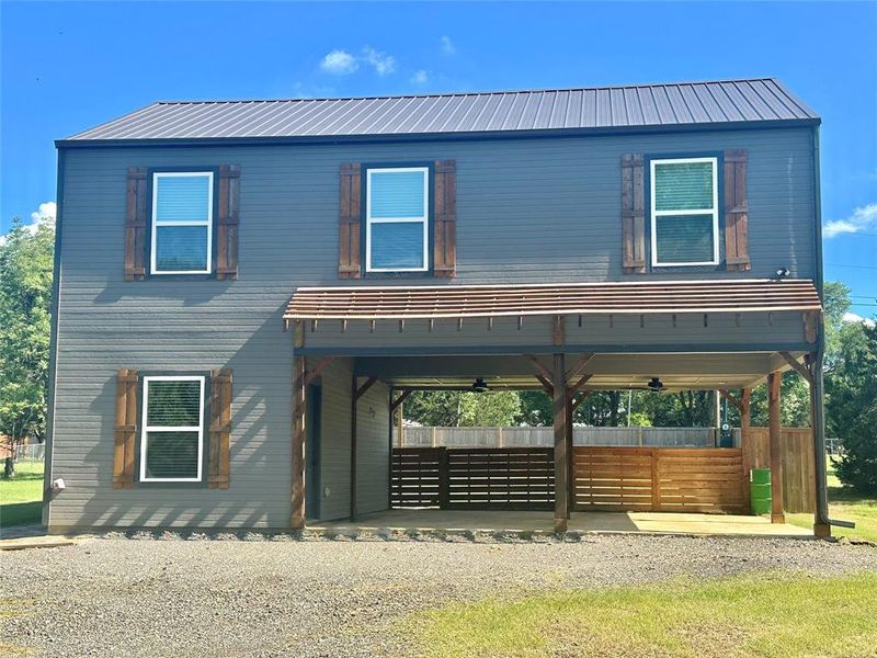 View of front of property featuring a metal roof, a carport, and gravel driveway View of front of property featuring a metal roof, a carport, and gravel driveway