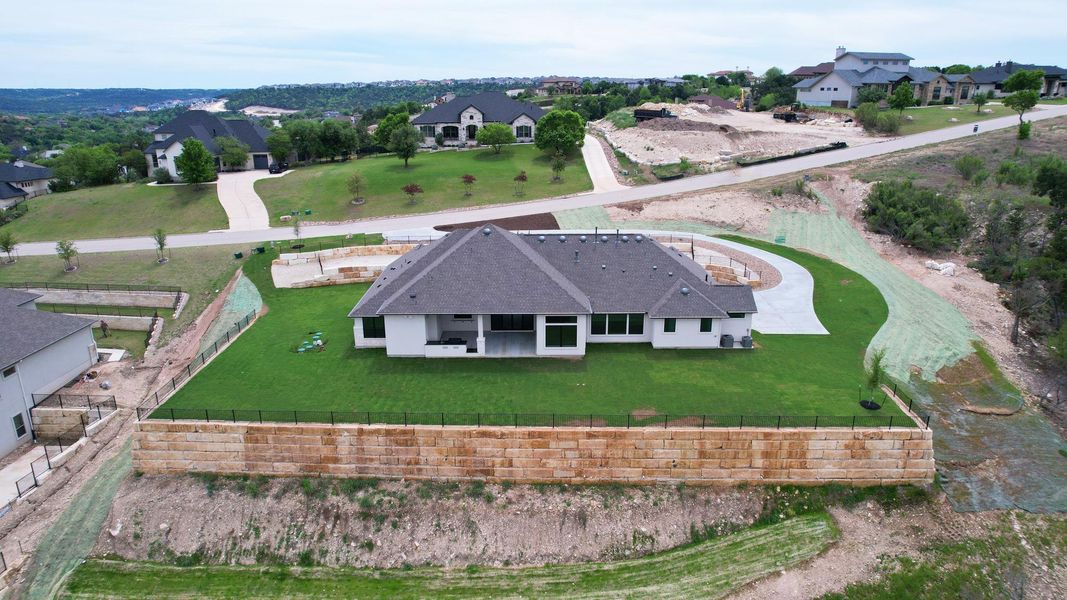 A newly constructed residence features pristine landscaping and a sturdy retaining wall, offering a private yard with expansive views. A newly constructed residence features pristine landscaping and a sturdy retaining wall, offering a private yard with expansive views.