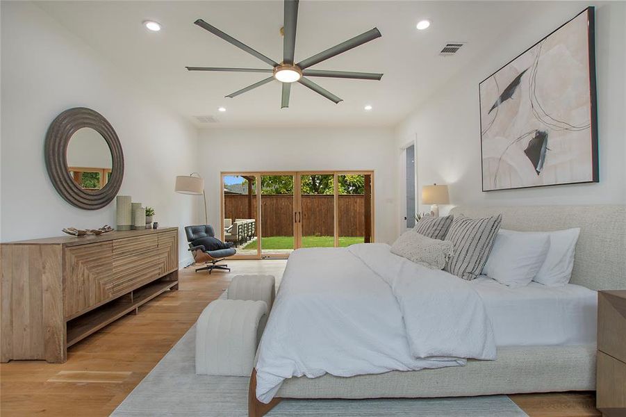 Bedroom with light hardwood / wood-style floors, ceiling fan, and access to exterior