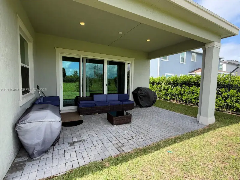 Covered patio featuring a paver surface, recessed lighting, and sliding glass doors