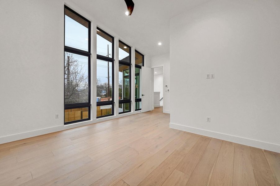 Unfurnished room featuring light wood-style floors, floor to ceiling windows, and recessed lighting