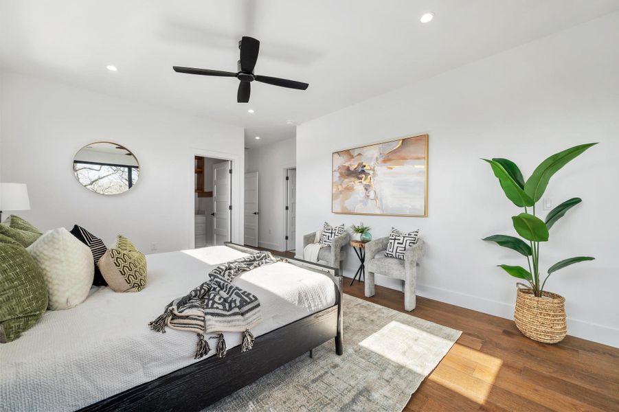 Bedroom featuring a ceiling fan, wood finished floors, baseboards, ensuite bath, and recessed lighting