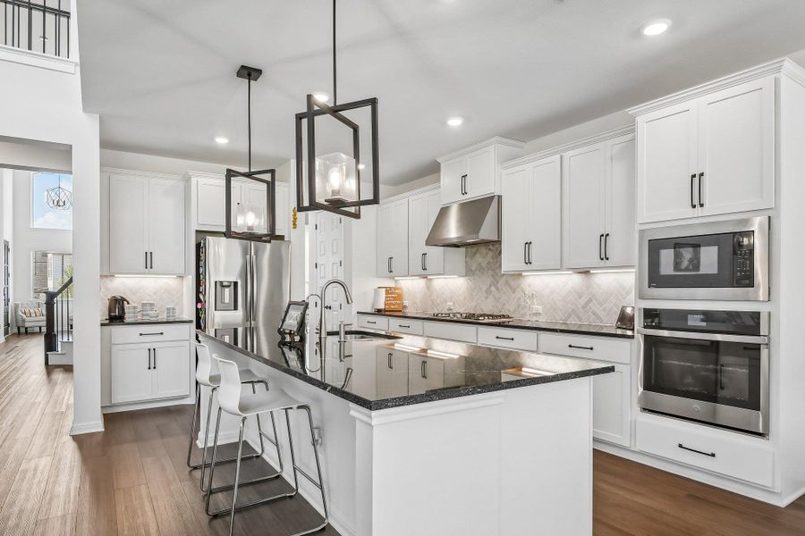 Culinary delights await in this bright kitchen with a spacious island, premium appliances, and rich hardwood flooring.