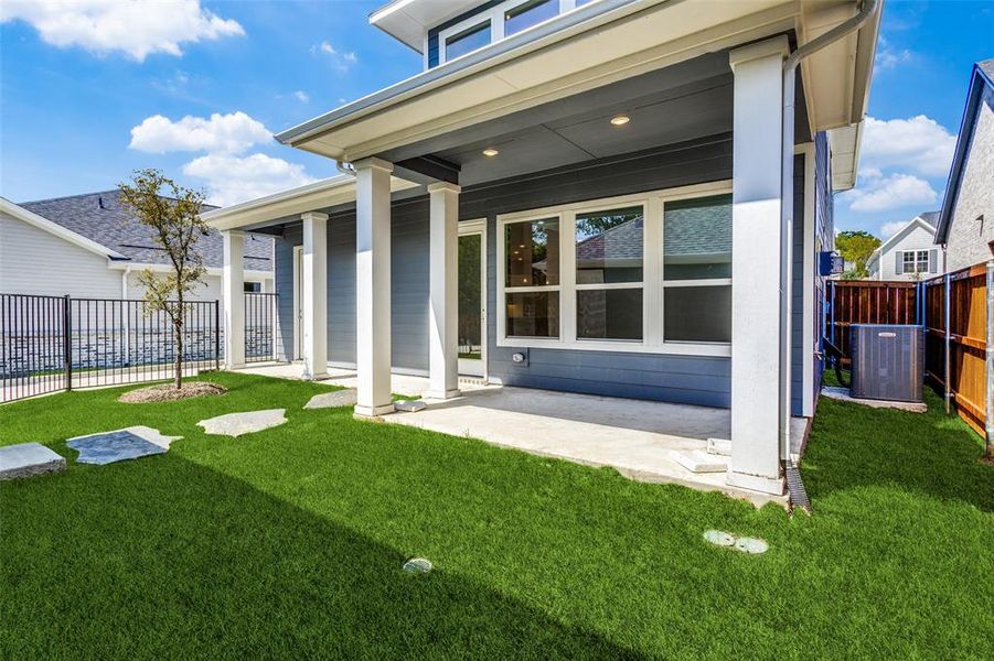 Back of house featuring a lawn and central air condition unit