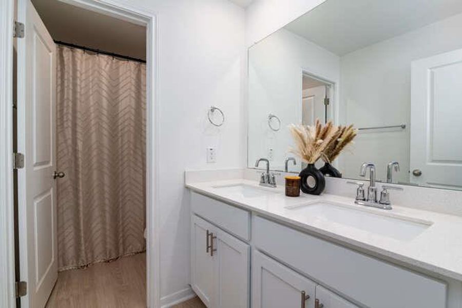 Full bath featuring double vanity, wood finished floors, and a shower with curtain
