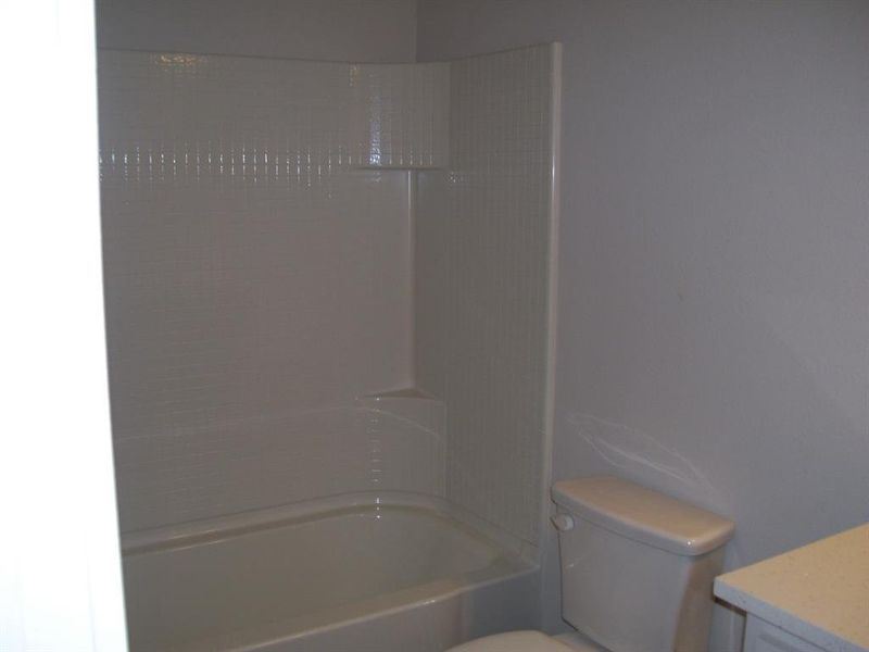 Full bathroom featuring toilet, vanity, and tub / shower combination