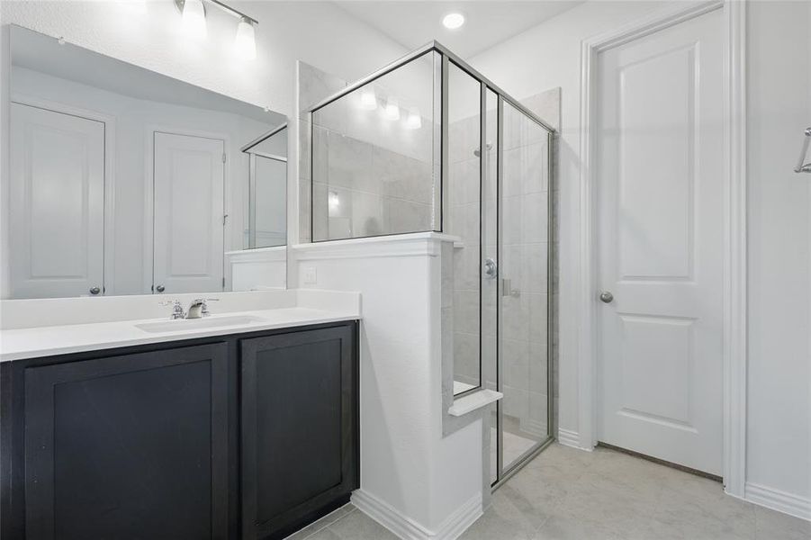 Full bathroom with a shower stall, vanity, and baseboards Full bathroom with a shower stall, vanity, and baseboards