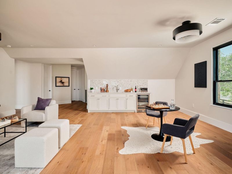 Ample natural light illuminates a versatile bonus room with hardwood flooring and a built-in wet bar. Ample natural light illuminates a versatile bonus room with hardwood flooring and a built-in wet bar.
