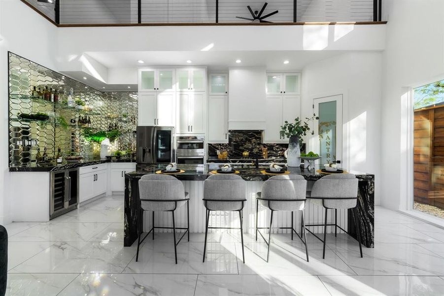 Kitchen island with enough seating for 4. Bar area with sink, wine fridge and mirrored tile. Kitchen island with enough seating for 4. Bar area with sink, wine fridge and mirrored tile.