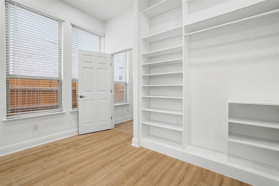 Walk in closet with light wood-style floors