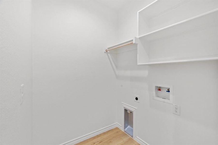 Washroom with hookup for an electric dryer, washer hookup, and light wood-type flooring Washroom with hookup for an electric dryer, washer hookup, and light wood-type flooring