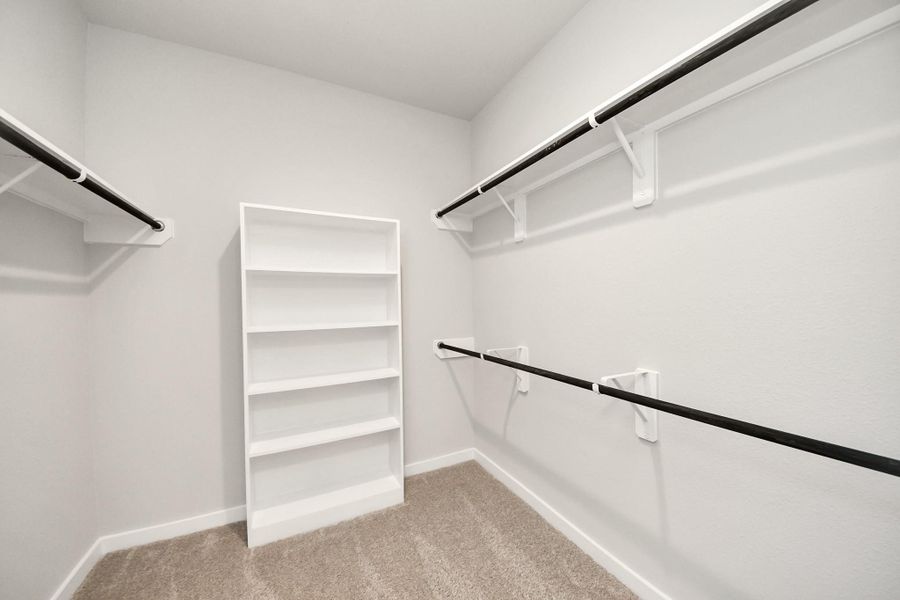 Walk-in closet that epitomizes luxury and practicality. This generously sized space features built-in shelving, offering abundant room for impeccable organization. High ceilings and recessed lighting create a bright and welcoming ambiance. Sample photo of completed home with similar floor plan. Actual colors and selections may vary. Walk-in closet that epitomizes luxury and practicality. This generously sized space features built-in shelving, offering abundant room for impeccable organization. High ceilings and recessed lighting create a bright and welcoming ambiance. Sample photo of completed home with similar floor plan. Actual colors and selections may vary.