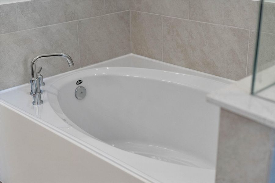 Unwind after a long day in the deep, corner soaking tub, a perfect sanctuary for relaxation. The tub is accented by stylish fixtures. Unwind after a long day in the deep, corner soaking tub, a perfect sanctuary for relaxation. The tub is accented by stylish fixtures.