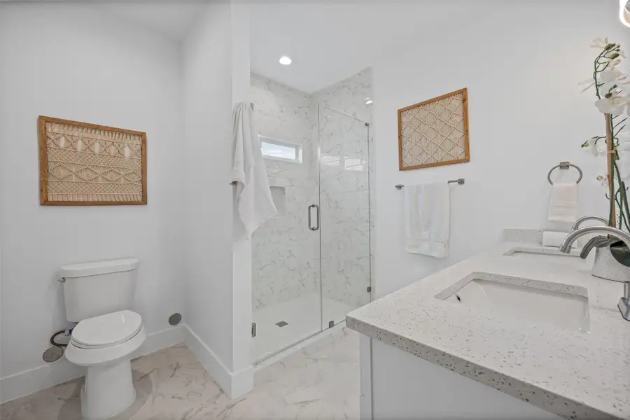 Dual vanity sinks and a spacious shower elevate daily routines in this modern bathroom. Dual vanity sinks and a spacious shower elevate daily routines in this modern bathroom.