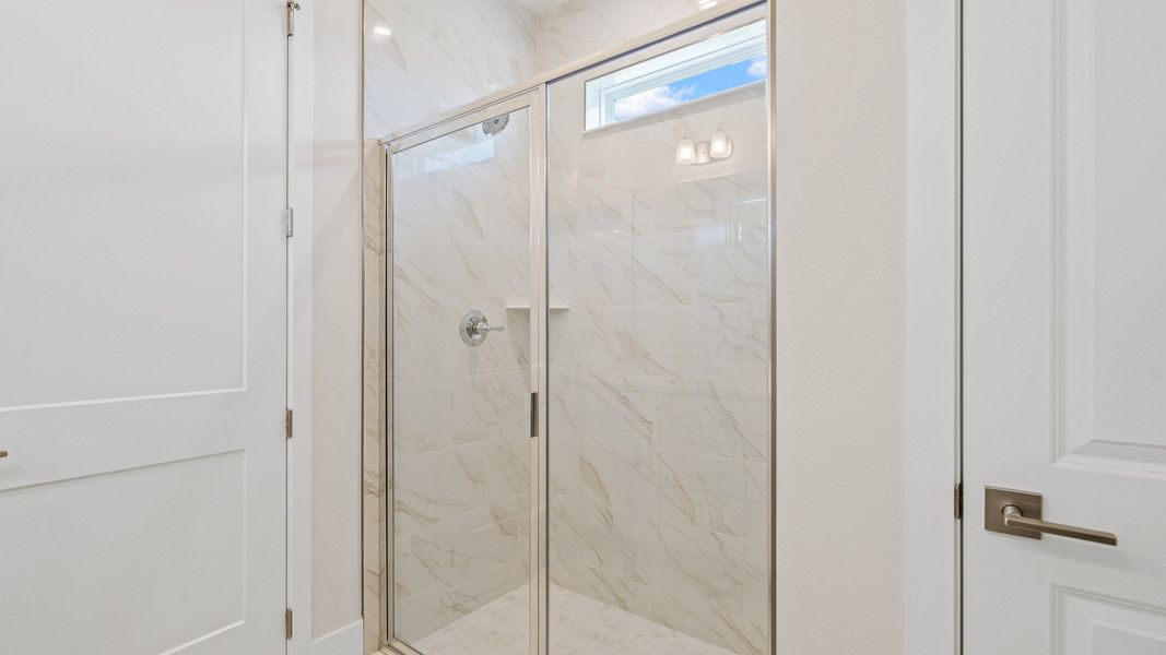 The Sweetgum Spacious and Bright first floor primary suite en-suite bath with dual sinks in Trailside Mount Dora by DRB Homes