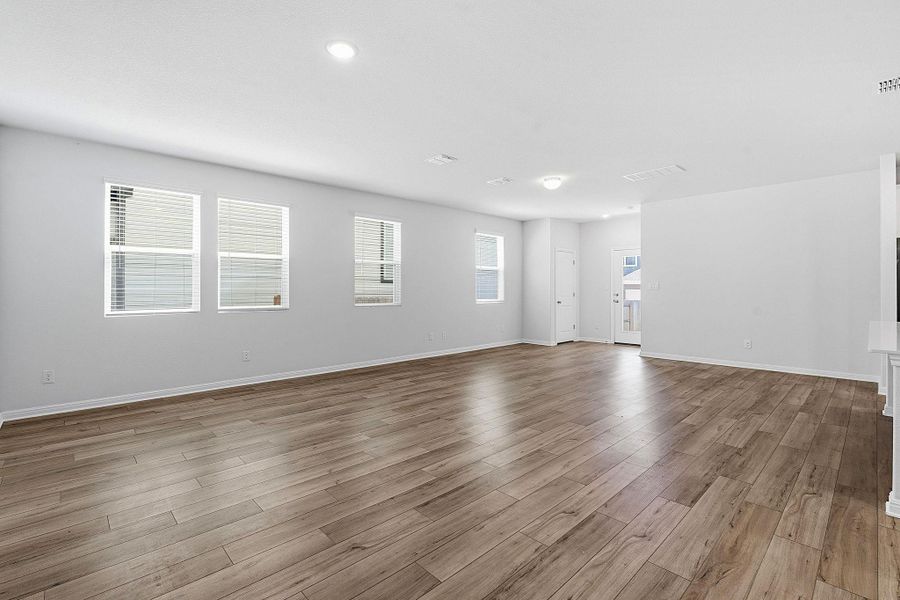 A generously proportioned living space with durable wood-look flooring awaits personalization. A generously proportioned living space with durable wood-look flooring awaits personalization.