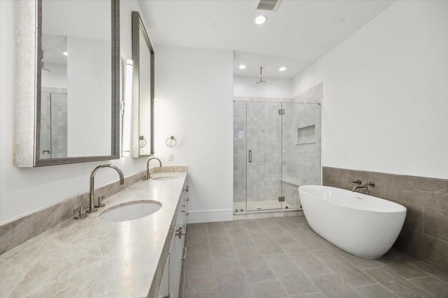 Primary bathroom features a Sterling Unwind freestanding oval soaking tub with Kallista One wall-mounted faucet, framed glass shower with Laticrete shower system. Primary bathroom features a Sterling Unwind freestanding oval soaking tub with Kallista One wall-mounted faucet, framed glass shower with Laticrete shower system.