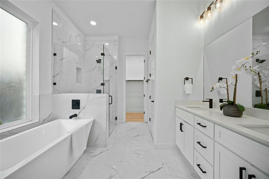 Bathroom with marble finish floors, double vanity, a freestanding bath, a marble finish shower, and recessed lighting Bathroom with marble finish floors, double vanity, a freestanding bath, a marble finish shower, and recessed lighting