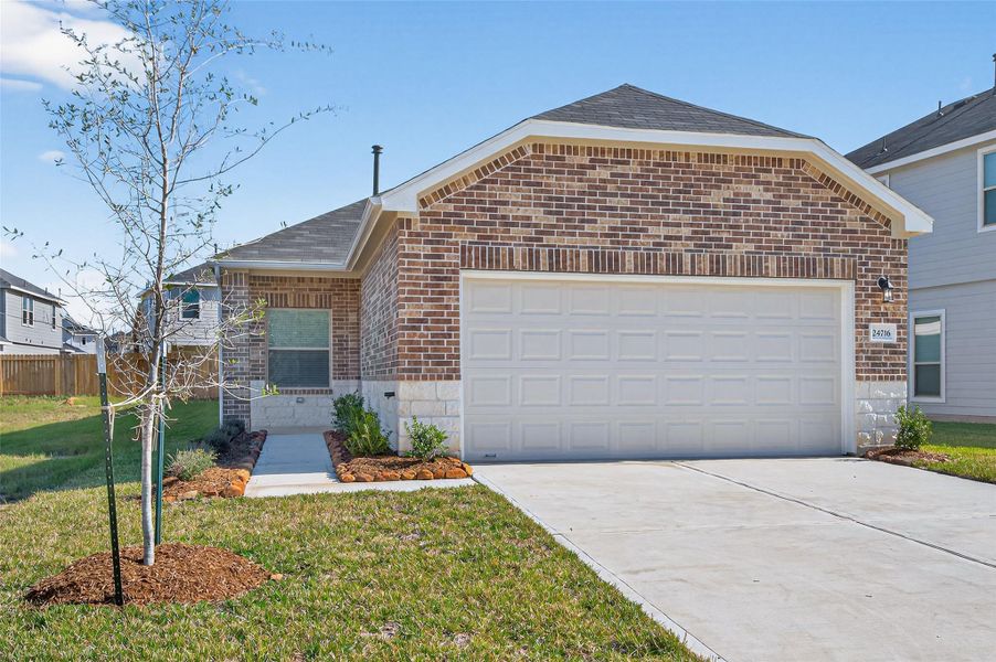 Front exterior of a new home in Woodland Lakes, Huffman, TX, highlighting curb appeal (Image 24).