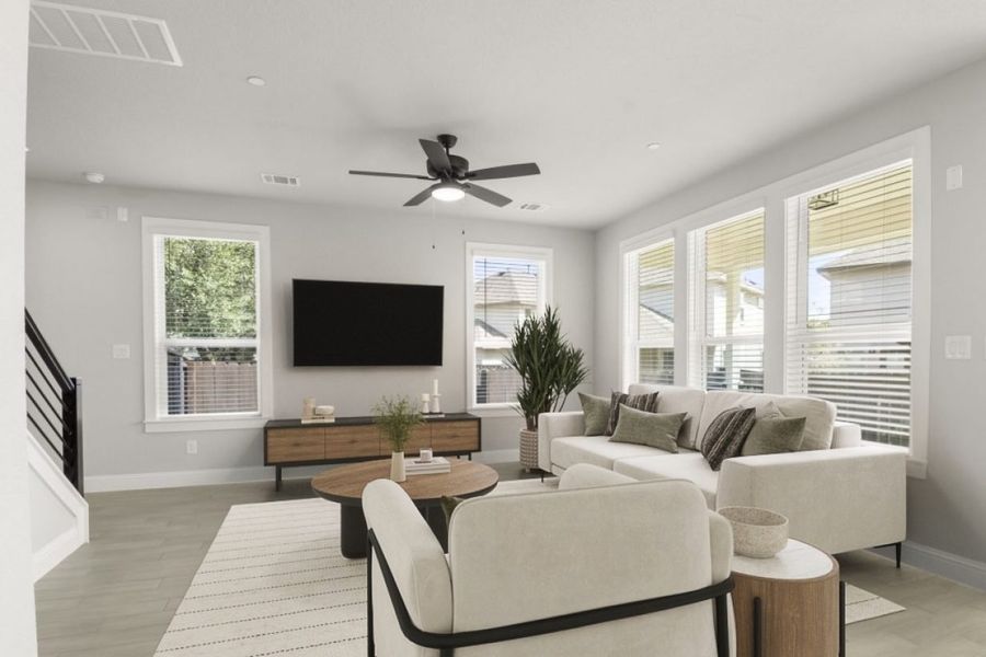 Image of a living room interior staged with modern sofas, a white rug, wooden coffee table ,TV stand and a mounted TV