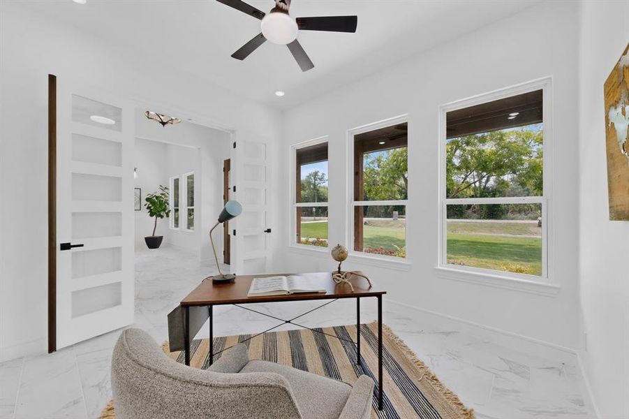 Bright room featuring three large windows, white walls, recessed lighting, and a ceiling fan