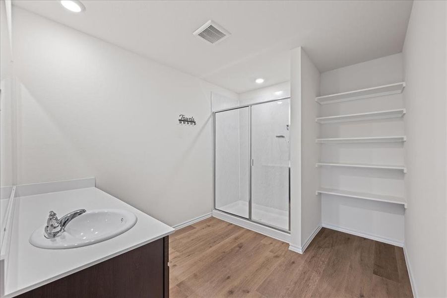 Bathroom with a shower stall, light wood-style floors, vanity, and recessed lighting Bathroom with a shower stall, light wood-style floors, vanity, and recessed lighting