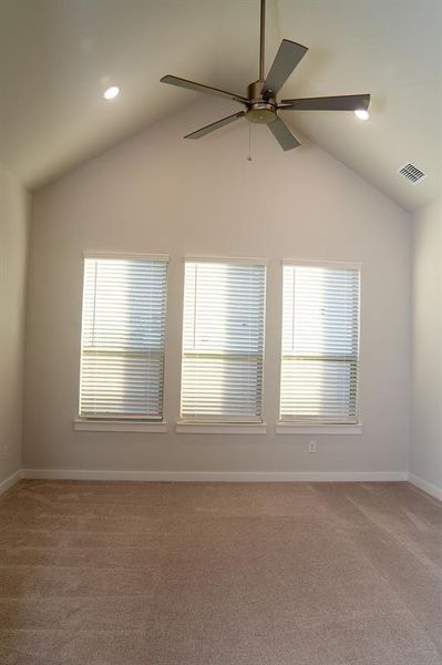 Vaulted ceiling room featuring three windows with blinds, recessed lighting, and a ceiling fan with integrated lighting Vaulted ceiling room featuring three windows with blinds, recessed lighting, and a ceiling fan with integrated lighting