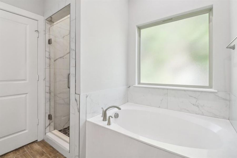 Bathroom featuring separate shower and tub and hardwood / wood-style flooring