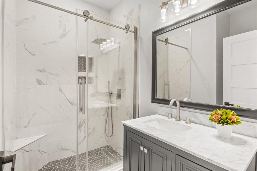 Full bathroom with a marble finish shower and vanity