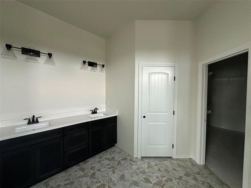 Full bath with double vanity and a spacious closet