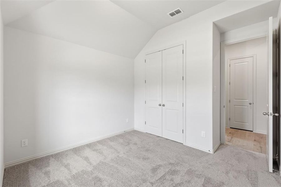 Carpeted room featuring a white painted ceiling with an attic access hatch Carpeted room featuring a white painted ceiling with an attic access hatch