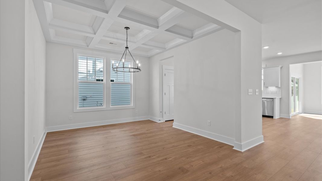 Desirable dining room with coffered ceiling and modern elegance in an established community Desirable dining room with coffered ceiling and modern elegance in an established community