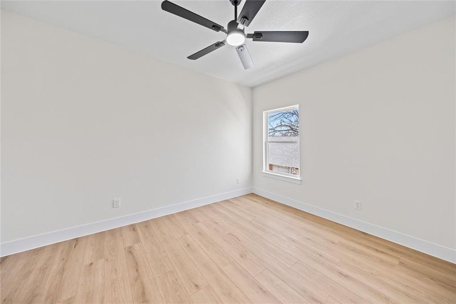 Unfurnished room featuring light wood finished floors and a ceiling fan Unfurnished room featuring light wood finished floors and a ceiling fan