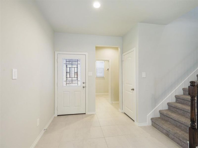 Entryway with light tile patterned floors, baseboards, and stairs Entryway with light tile patterned floors, baseboards, and stairs