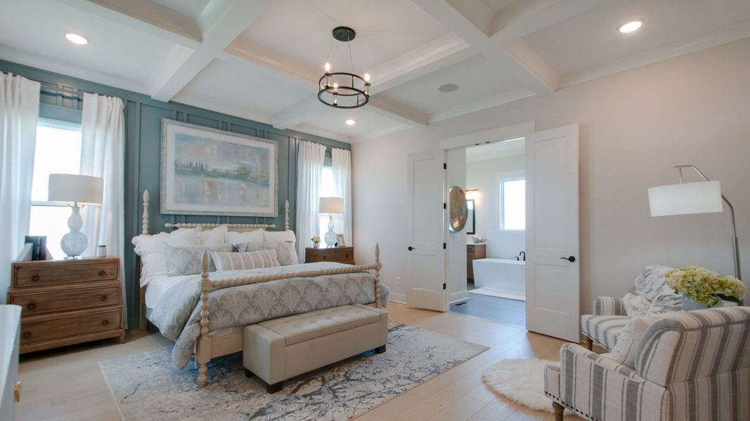 Large primary suite with trim-built coffered ceiling and entry to bathroom Large primary suite with trim-built coffered ceiling and entry to bathroom