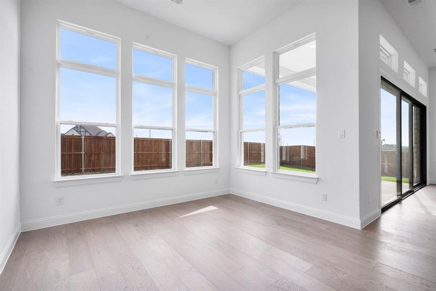 Dining area with light hardwood / wood-style flooring and a healthy amount of sunlight