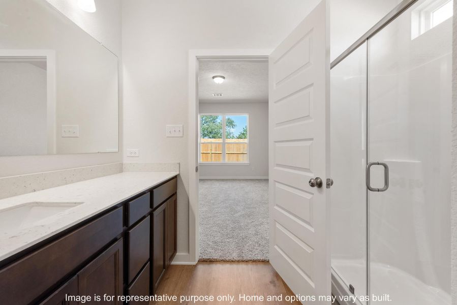 Bathroom featuring a stall shower, vanity, light wood-style floors, and a textured ceiling