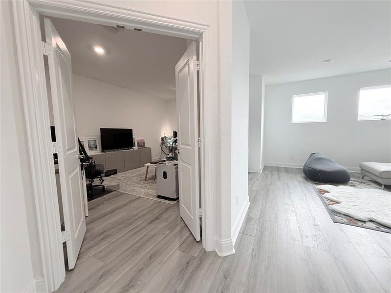 Hall with an office area and light wood-type flooring