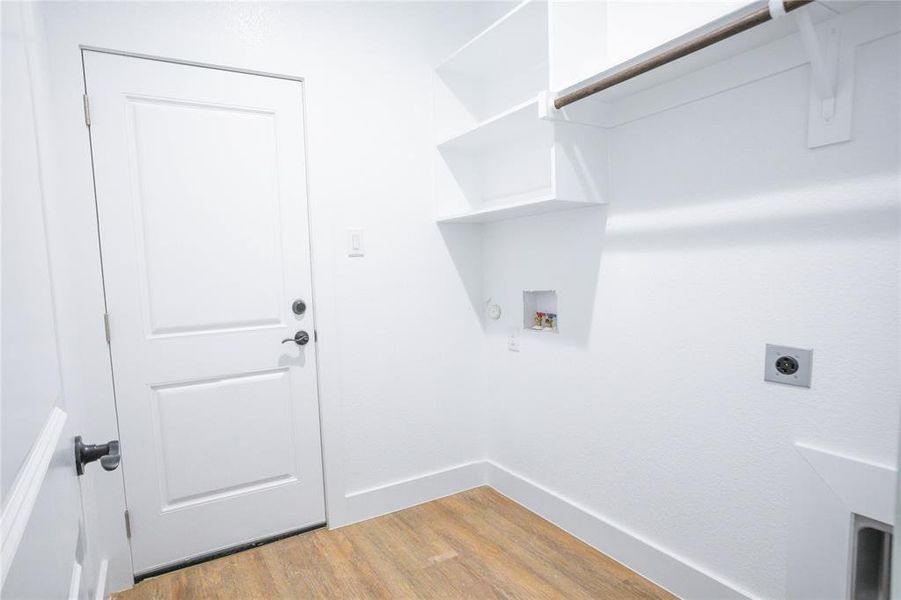 Washroom featuring wood finished floors, washer hookup, and hookup for an electric dryer